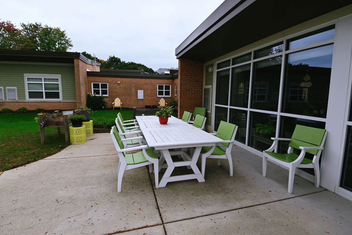 exterior gathering and eating area, flowers, tables and chairs